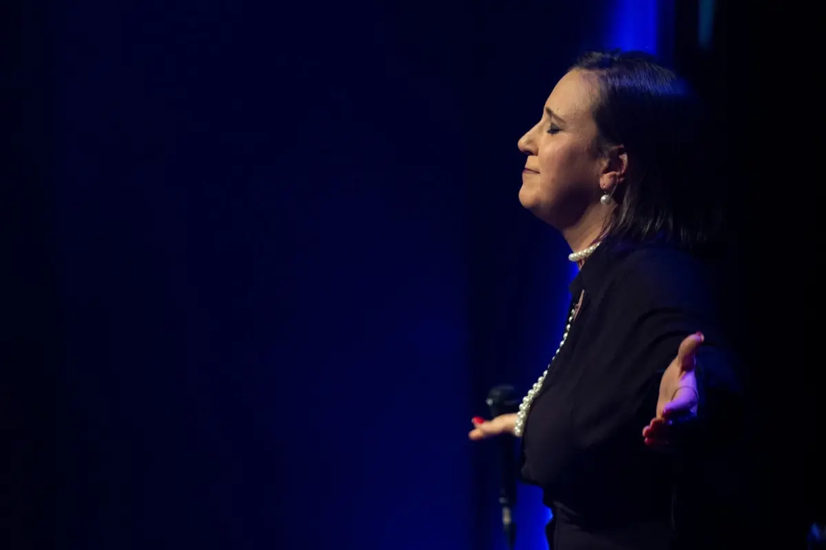 Vanessa Alves em palco com luz azul.